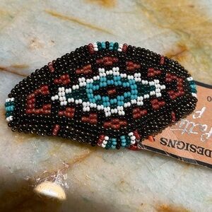 Indigenous vintage 1990s pin/broach with intricate bead work on soft leather.
